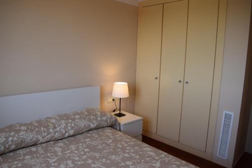 ラメトリャ・デ・マールにあるMSJ 87 Duplex Con Vistas al Mar (118)のベッドルーム1室(ベッド1台、キャビネット、ランプ付)