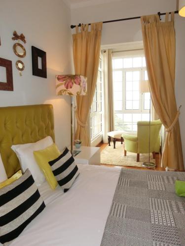 een slaapkamer met een groot bed met gele en witte kussens bij Casa Marias in Calheta