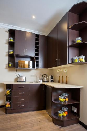a kitchen with dark brown cabinets and a counter at Villa Monticello Boutique Hotel in Accra