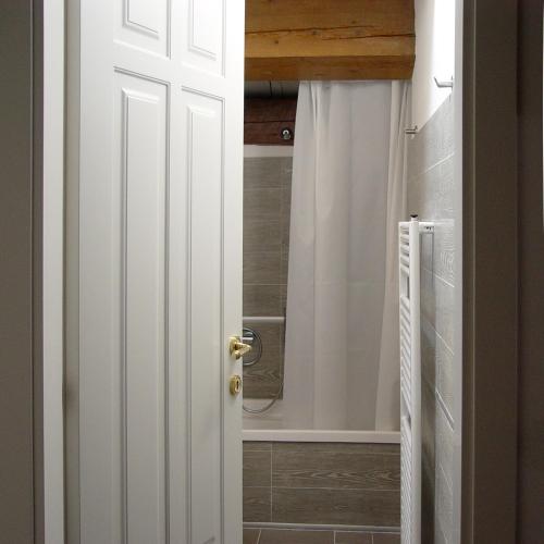 a bathroom with a shower and a white door at M Club De Luxe B&B in Ravenna