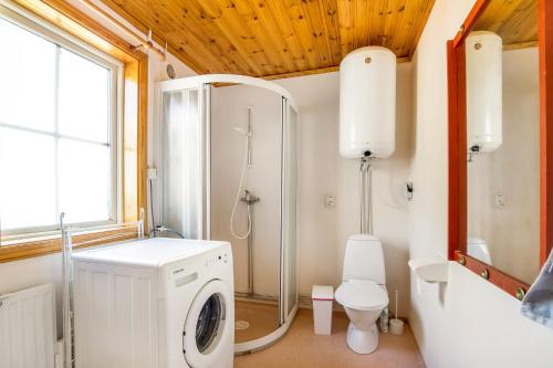 uma casa de banho com uma máquina de lavar roupa e um chuveiro em Holiday Lakefront house em Björköby