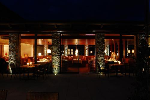 a restaurant with tables and chairs at night at Hotel Lauterbad in Freudenstadt