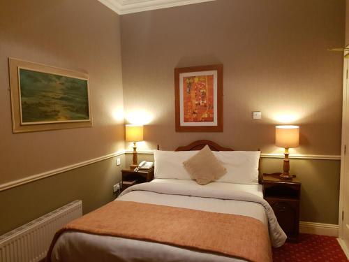 pokój hotelowy z łóżkiem i 2 lampami w obiekcie Royal Spa Hotel w mieście Lisdoonvarna
