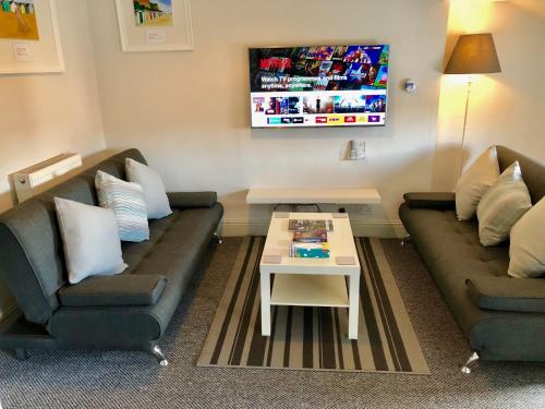 a living room with two couches and a coffee table at Stay Lytham Serviced Apartments in Lytham St Annes