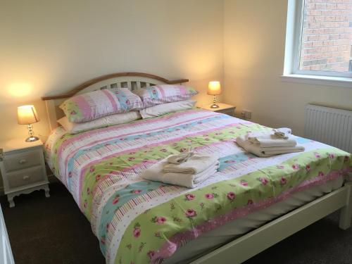 a bedroom with a bed with towels on it at Morning Field Apartment Free Parking in Inverness
