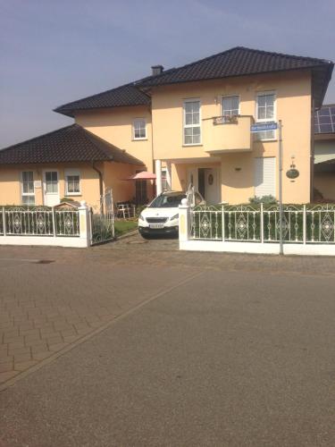 a house with a car parked in front of it at Gästehaus Tante Tienchen 7 Minuten zu Fuss zum Europa Park , plus kostenloses Parkplatzticket Rulantica ,alle unsere Suiten haben einen Balkon in Rust