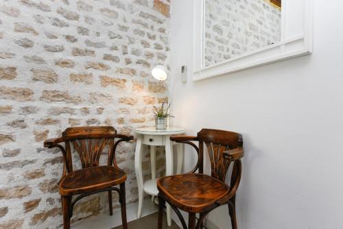 two chairs and a table in a room with a brick wall at Accomodation Gina in Zadar