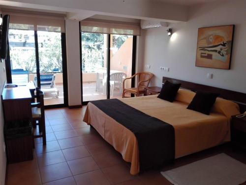a bedroom with a large bed and a balcony at Hotel Balaia Mar in Albufeira