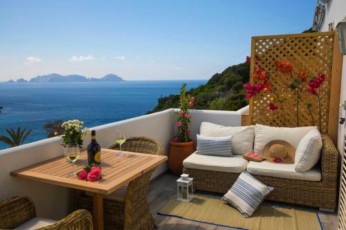 einen Balkon mit einem Tisch, Stühlen und Meerblick in der Unterkunft Maridea Casa Vacanza- Le Alcove sul Mare Suites in Ponza