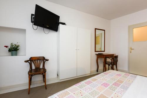 a bedroom with a bed and a tv on the wall at Accomodation Gina in Zadar