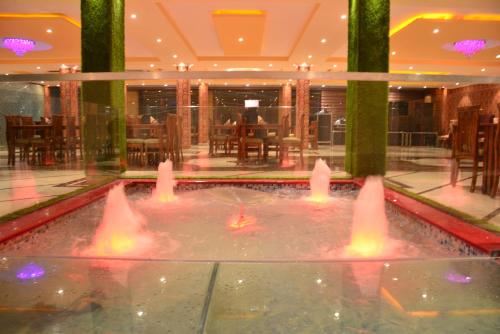 a fountain in the middle of a hotel lobby at Hotel Kings Regency in Drang