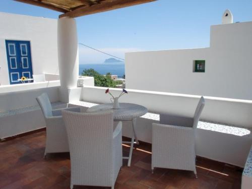 una mesa y sillas en un balcón con vistas en SalinArte, en Santa Marina Salina
