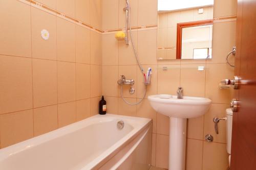 a bathroom with a sink and a bath tub and a toilet at Apartment with pool in Becici
