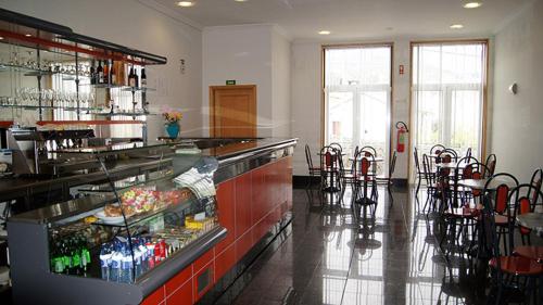a restaurant with a counter and chairs in a room at Kolping House in Lamego