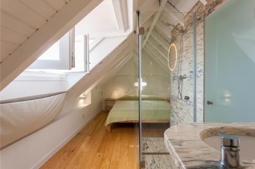 uma casa de banho com uma cama e uma cabina de duche em vidro em Lisbon Sea Side Chalet em Paço de Arcos
