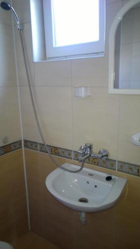 a bathroom with a sink and a window at Dracena Guesthouse in Ravda
