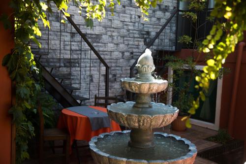 a fountain in the middle of a courtyard with a table at Hotel Rivera in Colonia del Sacramento