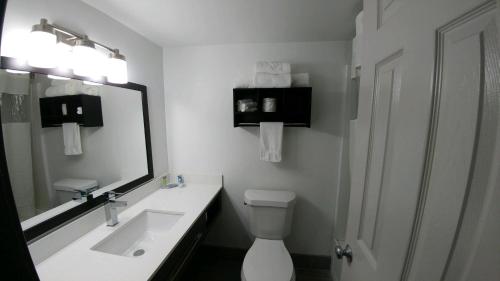 a bathroom with a sink and a toilet and a mirror at Garden City Inn in Myrtle Beach