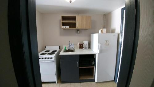 a small kitchen with a stove and a refrigerator at Garden City Inn in Myrtle Beach