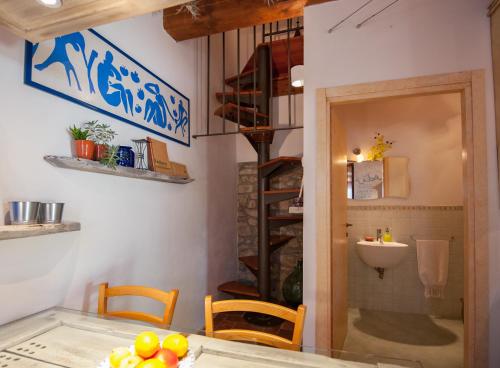 eine Küche mit einem Tisch und Stühlen sowie eine Wendeltreppe in der Unterkunft Fienile Vignanova in Gerfalco