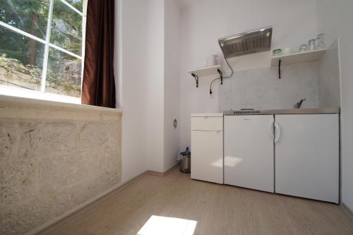 a kitchen with a white refrigerator and a window at White House Apartments in Korčula