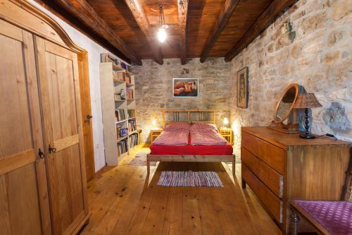 um quarto com uma cama e uma parede de pedra em Summerhouse Beram em Pazin