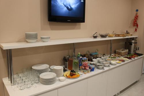 a shelf with plates and dishes and a tv on a wall at Boutique Hotel 32 in Batumi