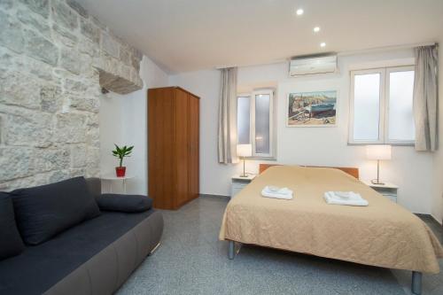 a bedroom with a bed and a couch at Apartments Galerija in Korčula