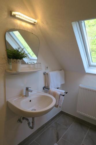 ein Bad mit einem Waschbecken und einem Spiegel in der Unterkunft Ferienhaus Mosel in Brauneberg