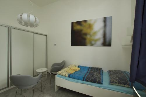 a small bedroom with a bed and a chair at Koleje Zamecek in Lednice