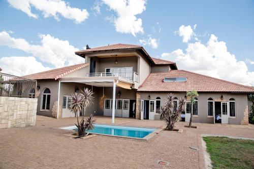 a house with a swimming pool in front of it at Blue Rain Guest House in Bloemfontein