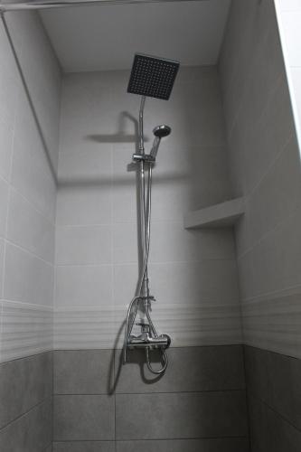 a shower in a bathroom with a fan on the wall at Boutique Hotel 32 in Batumi