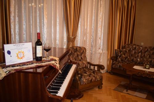 a bottle of wine sitting on a piano in a living room at Family Hotel Lago & Wine Cellar in Lagodekhi