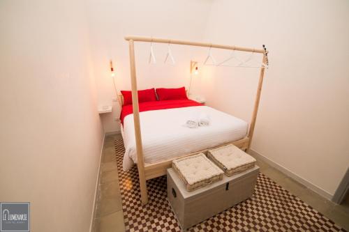モットラにあるLe luminarieの小さなベッドルーム(赤い枕付きのベッド付)