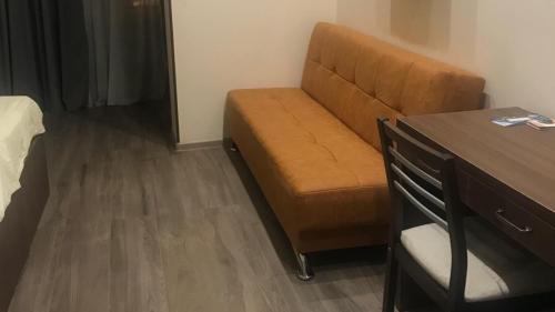a brown couch in a small room with a bed at Boutique Hotel 32 in Batumi