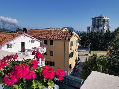 a balcony with pink flowers and a building at Apartments Tamara in Budva