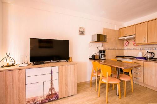 a kitchen with a table with chairs and a television at Penthouse with amazing views in Vina del Mar in Playa Fañabe