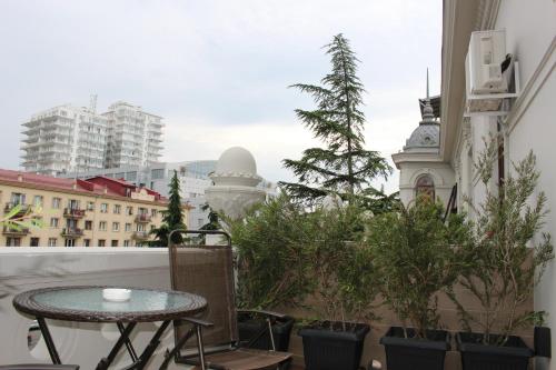 a balcony with a table and potted plants on it at Boutique Hotel 32 in Batumi