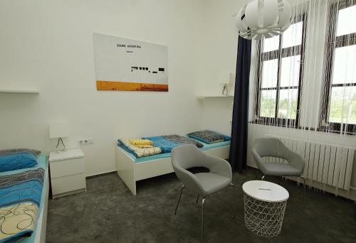 a room with two beds and a table and chairs at Koleje Zamecek in Lednice