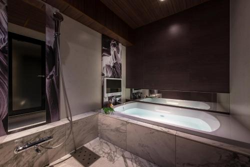 一宮市にあるHOTEL ZEN 一宮 (大人専用)の広いバスルーム(バスタブ、シャワー付)
