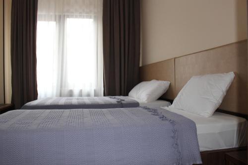 two beds in a hotel room with a window at Boutique Hotel 32 in Batumi