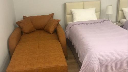 a couch next to a bed in a room at Boutique Hotel 32 in Batumi