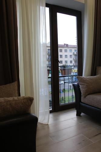 a living room with a window and a couch and a balcony at Boutique Hotel 32 in Batumi