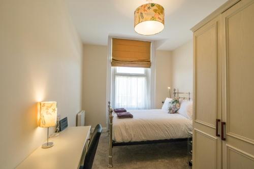 um pequeno quarto com uma cama e uma janela em Kingsway Apartment em Bishop Auckland