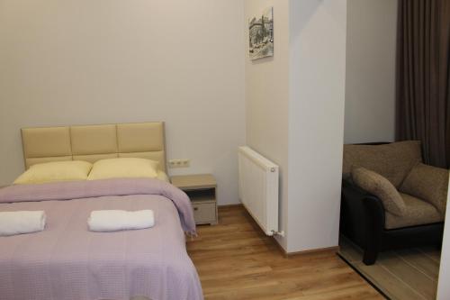 a small bedroom with a bed and a chair at Boutique Hotel 32 in Batumi