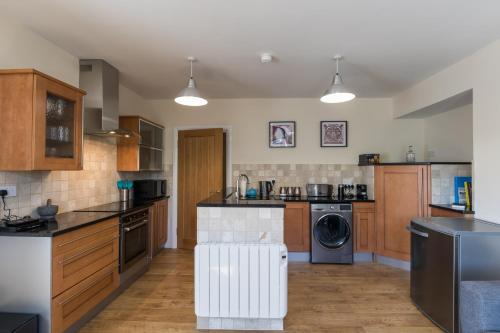 a large kitchen with wooden cabinets and a dishwasher at Kingsway Apartment in Bishop Auckland
