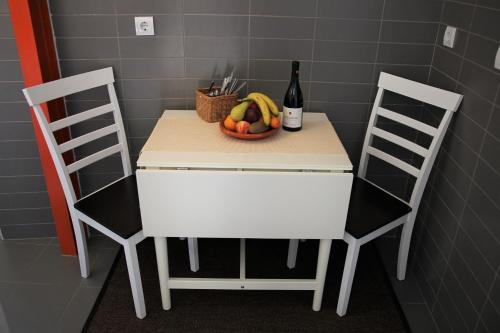a table with a bowl of fruit and a bottle of wine at The Back Street Nest in Lisbon