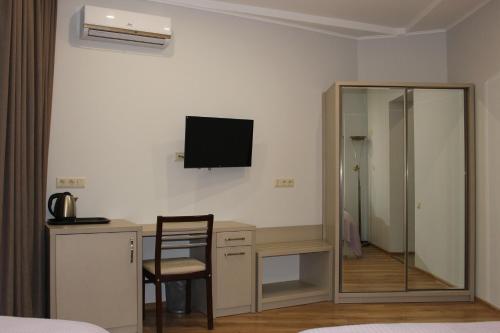 a bedroom with a desk and a television on the wall at Boutique Hotel 32 in Batumi