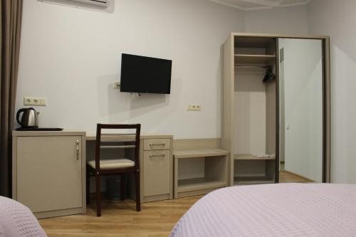 a bedroom with a bed and a desk and a tv at Boutique Hotel 32 in Batumi