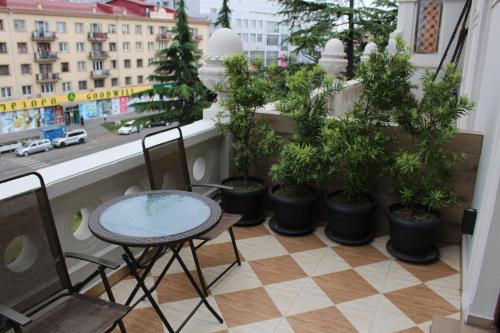 a balcony with a table and chairs and potted plants at Boutique Hotel 32 in Batumi
